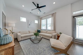 A living room with a ceiling fan, two couches, a coffee table, and a chair. at The Boardwalk at Tradition, Port St Lucie, Florida